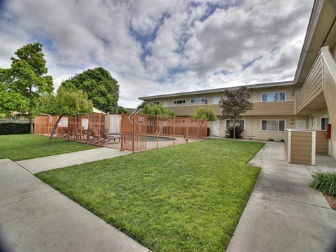 a yard in front of a house with a fence