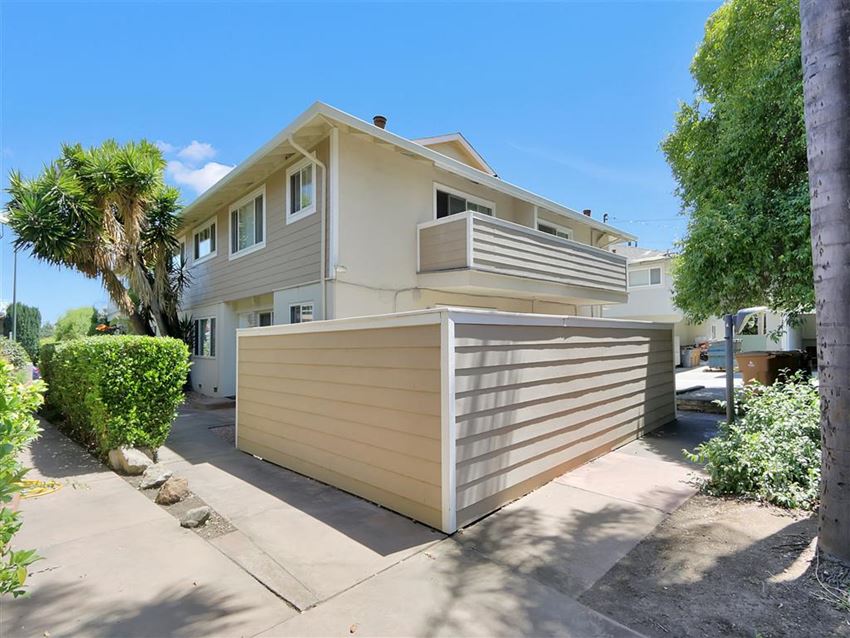 a house with a wooden fence and a driveway