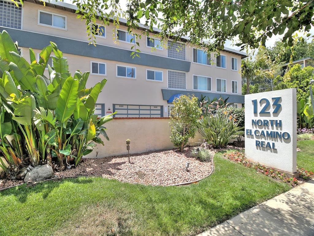 an apartment building with a sign in front of it