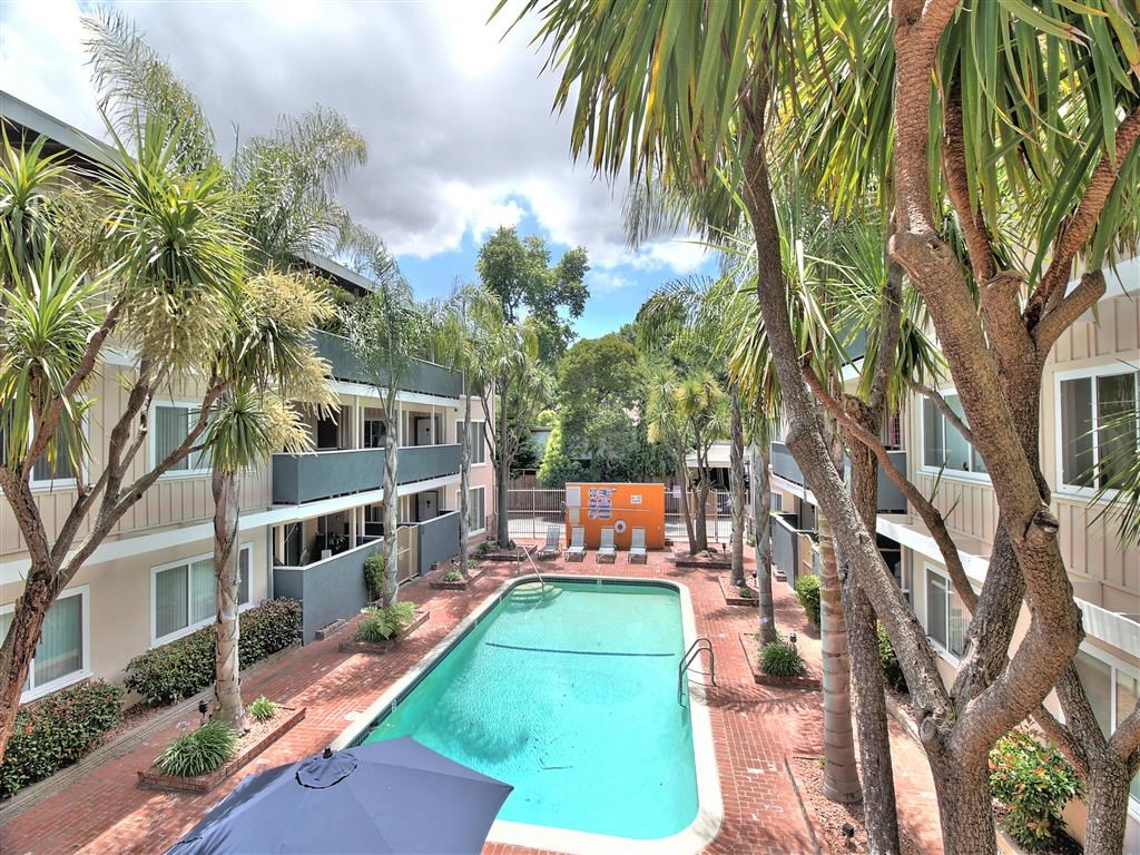 an apartment with a swimming pool and palm trees