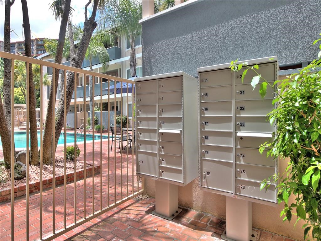 a group of mailboxes sitting next to a fence and a swimming pool