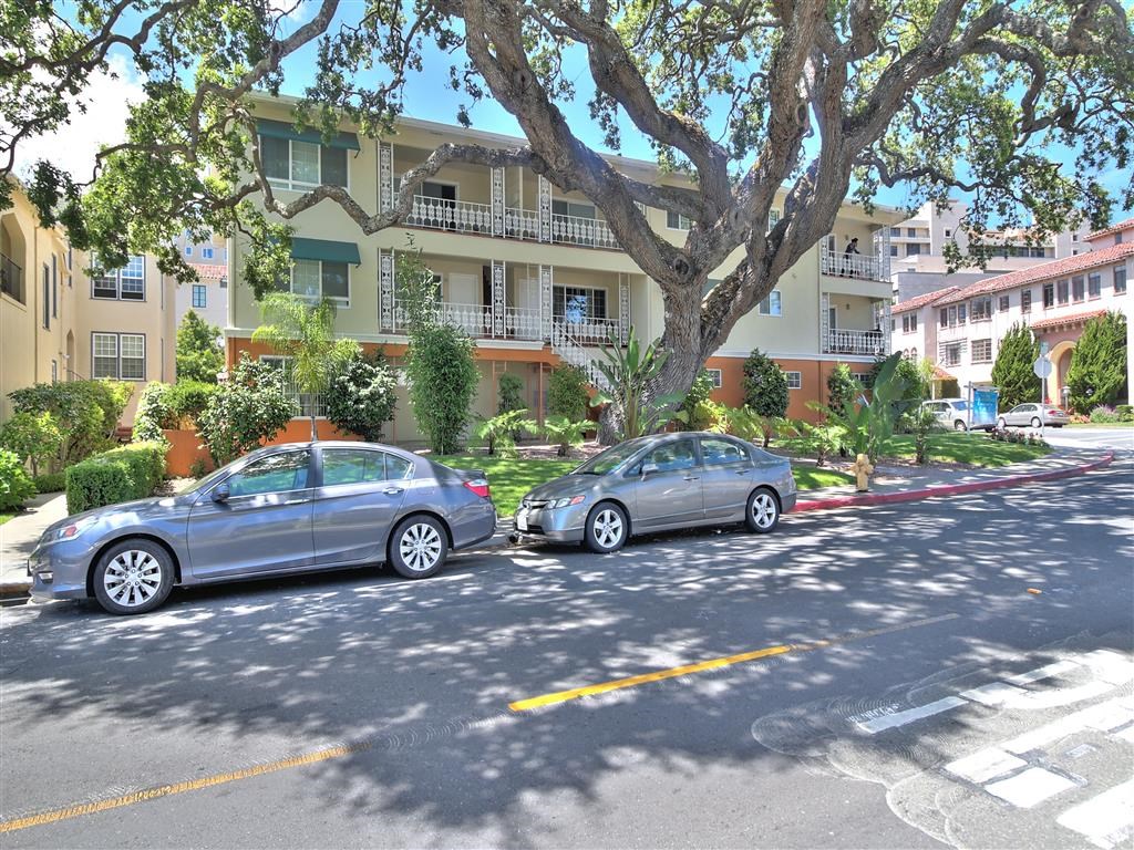 two cars parked in front of an apartment building