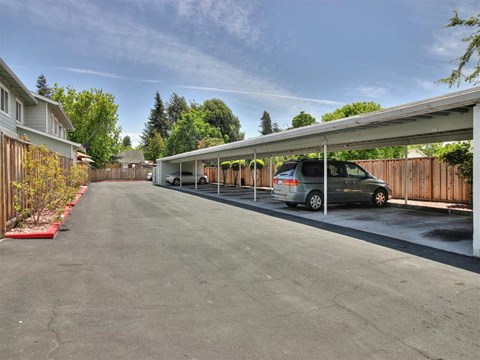 A car is parked under a covered driveway.