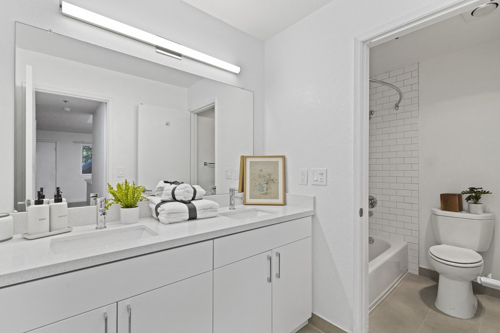 a bathroom with a large mirror and a sink and a toilet