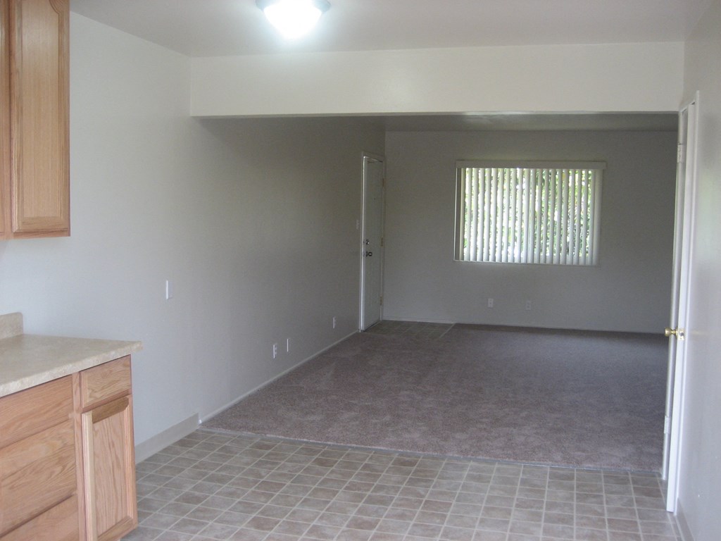 A room with a tile floor and a window with blinds.
