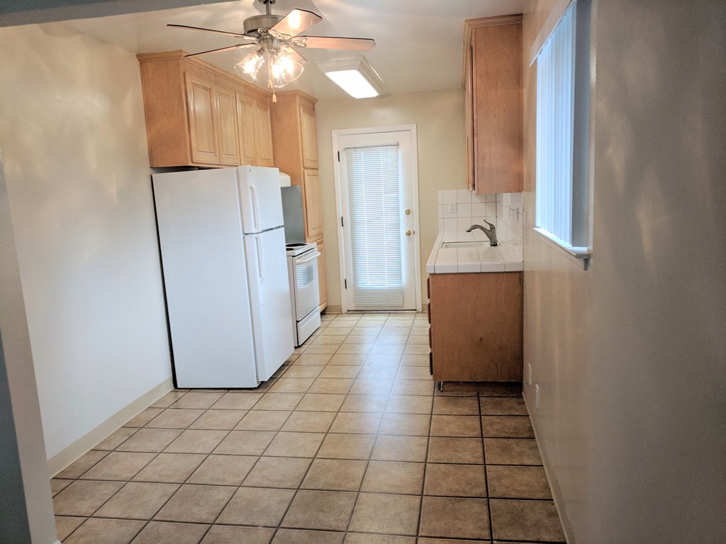 an empty kitchen with a refrigerator and a sink