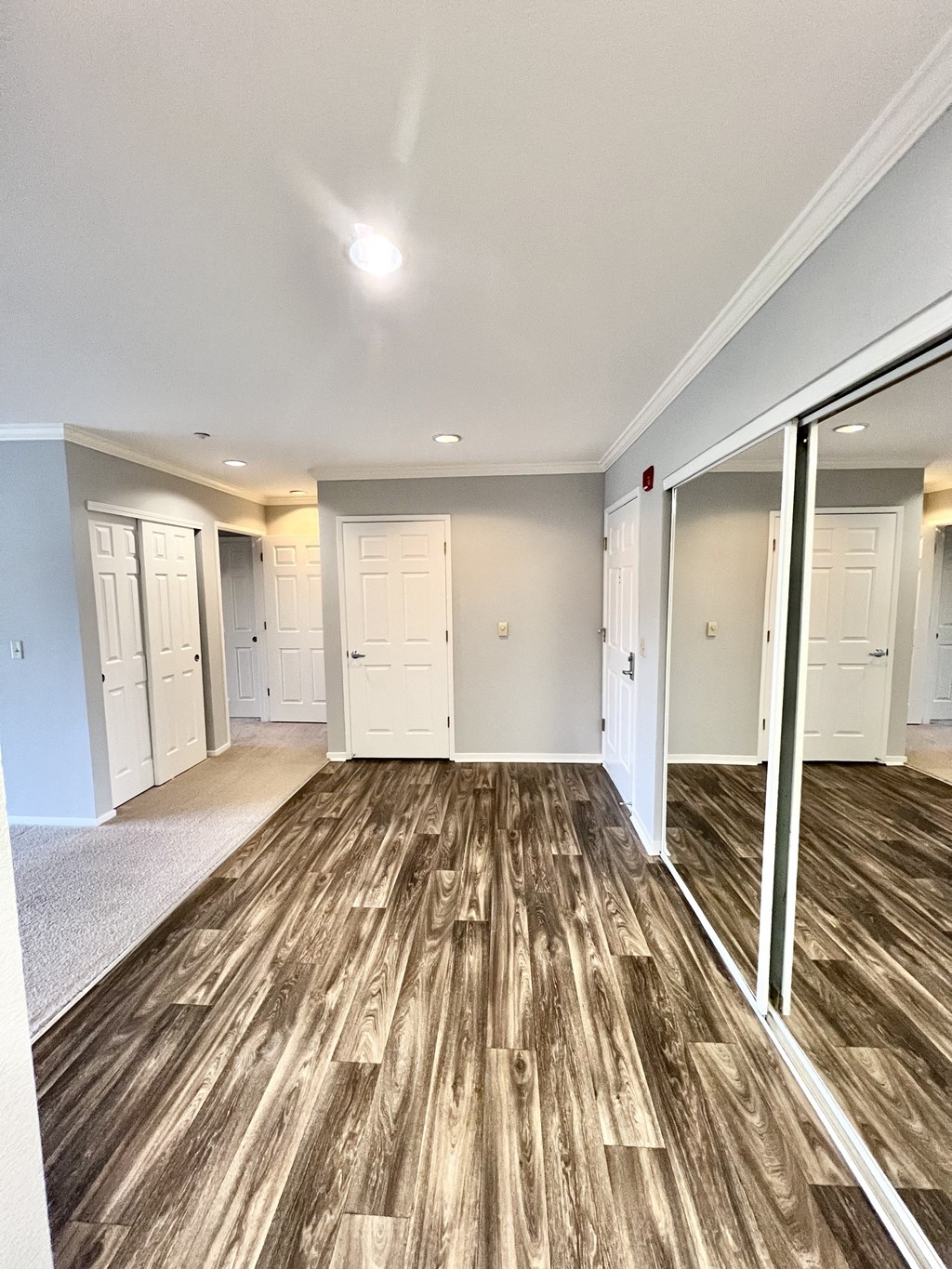 A room with wooden flooring and white walls.