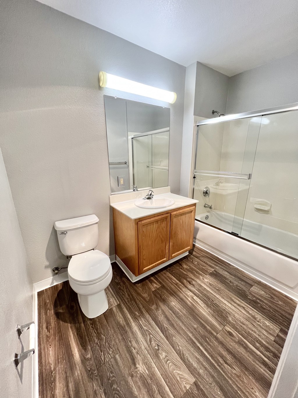 A white toilet sits next to a wooden cabinet in a bathroom.