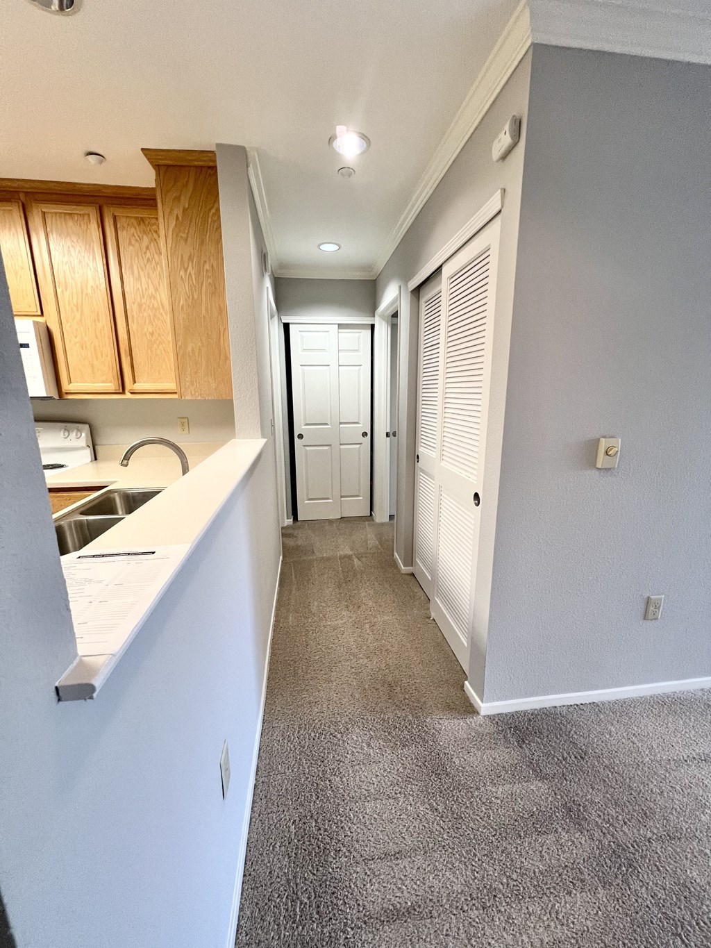 A long hallway with a white door at the end.