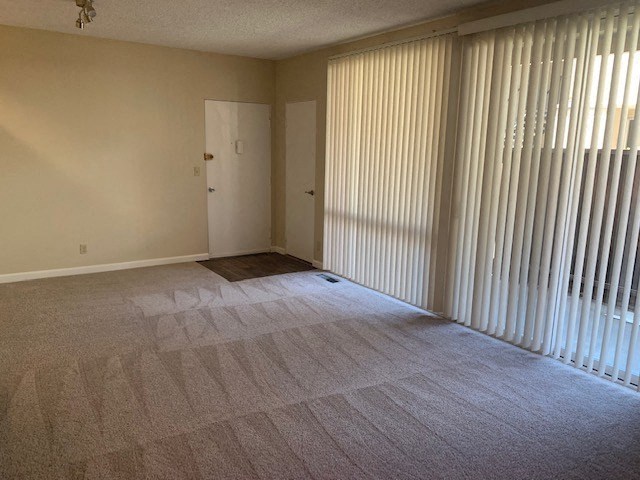 an empty living room with blinds on the window