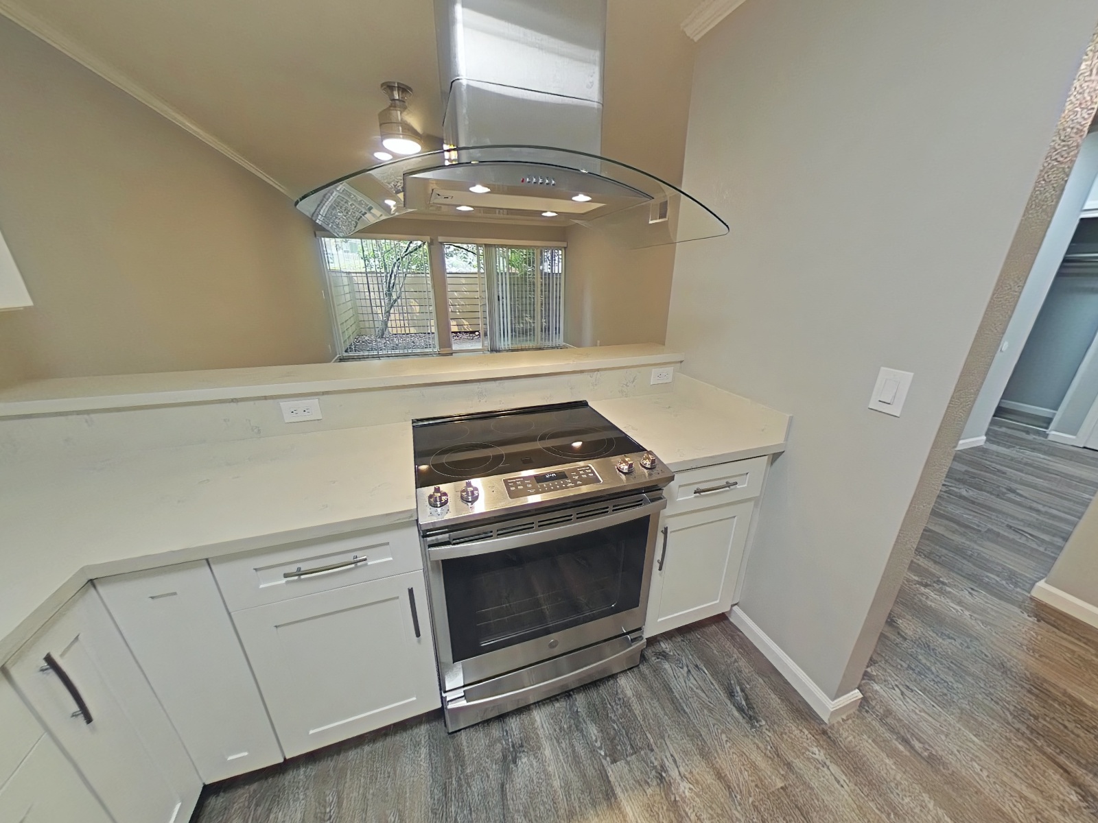 a kitchen with white cabinets and a stove and a window
