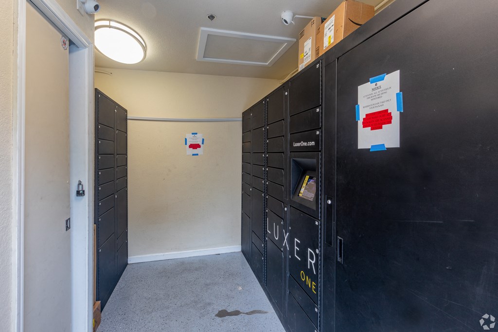 a room with black lockers and a hallway with a door