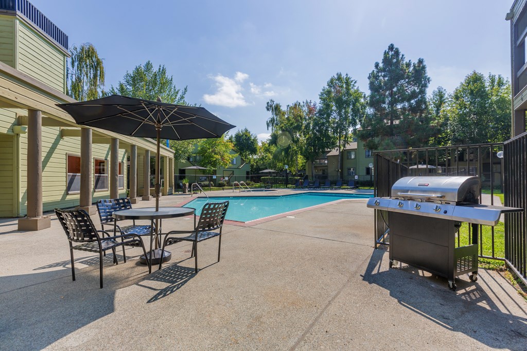 our apartments have a pool and patio with a grill and tables