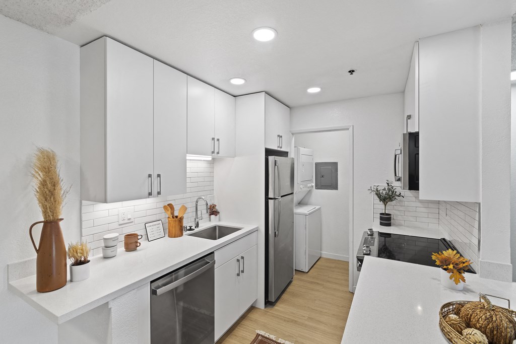 a renovated kitchen with white cabinets and stainless steel appliances