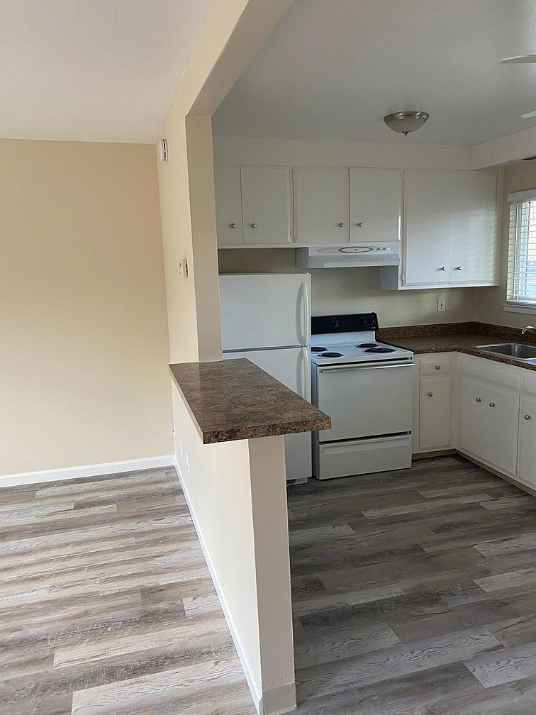 A kitchen with a white fridge and cabinets.