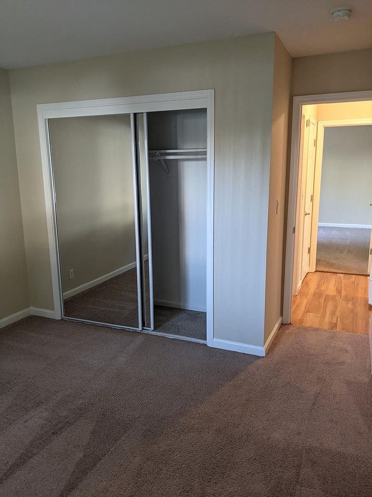 A room with a carpeted floor and a white door.