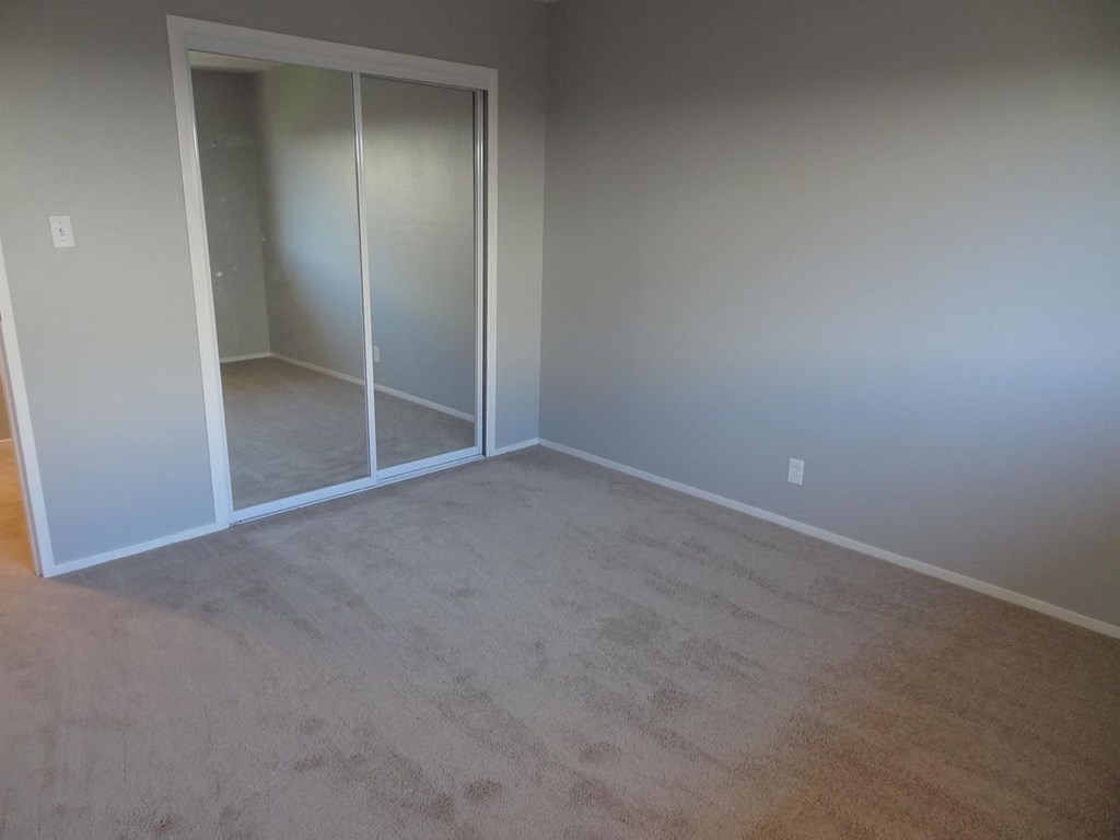 A room with a carpeted floor and a white door.