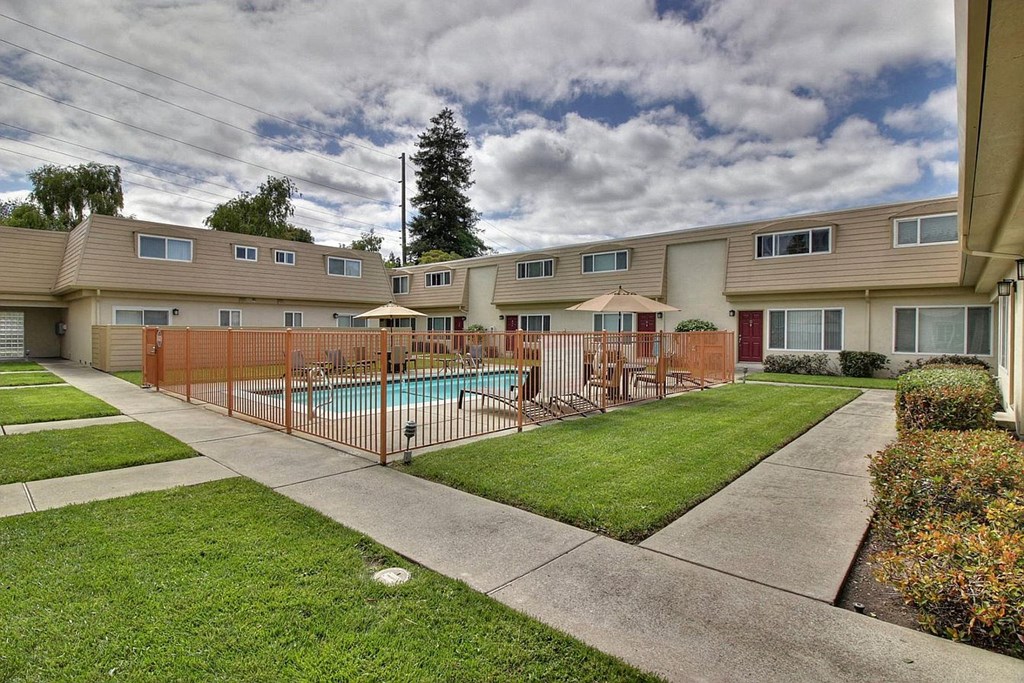 a yard with a swimming pool and a fence