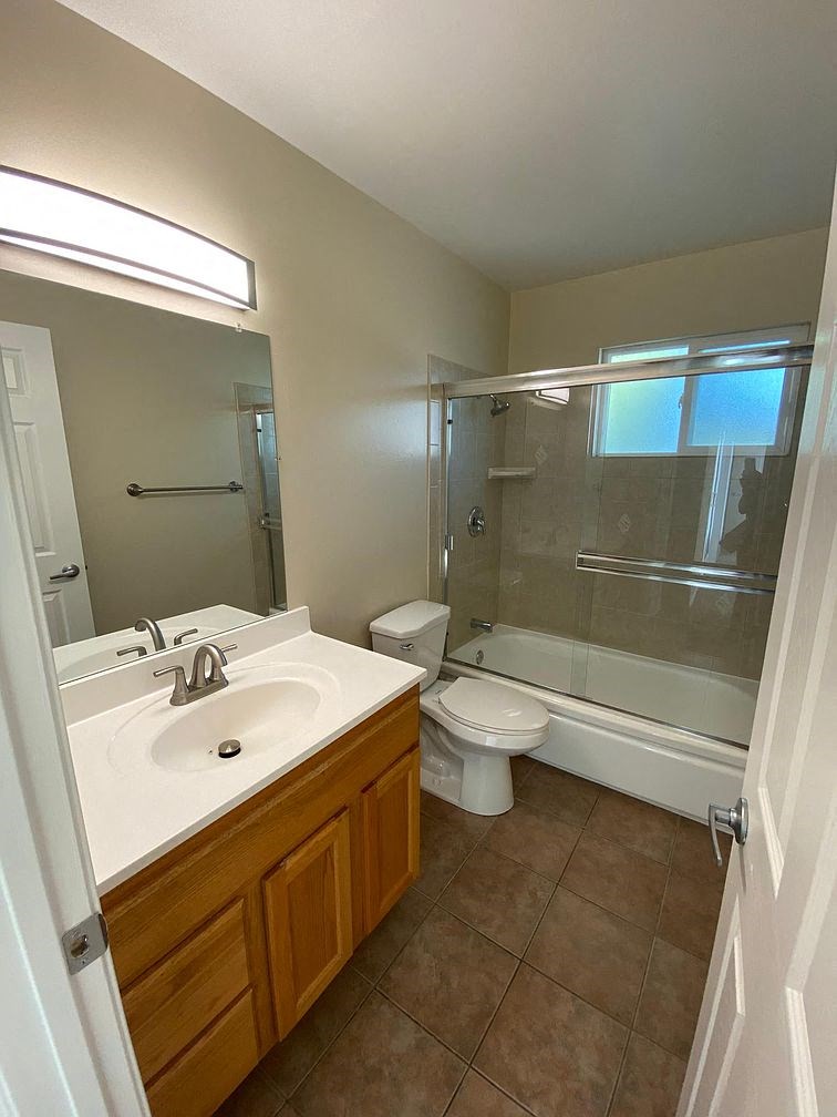 A bathroom with a sink, toilet, and shower.