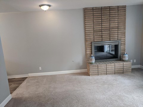A living room with a fireplace and a flat screen TV.