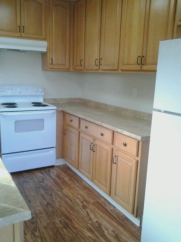 A kitchen with wooden cabinets and a white stove.