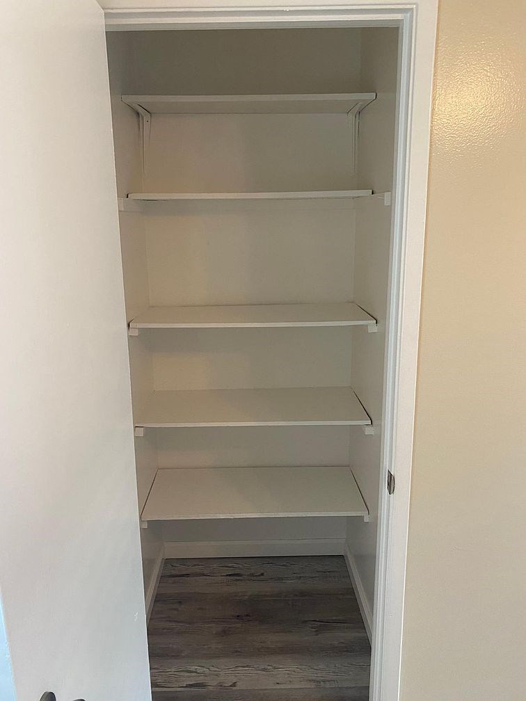 A white refrigerator with four shelves is open.
