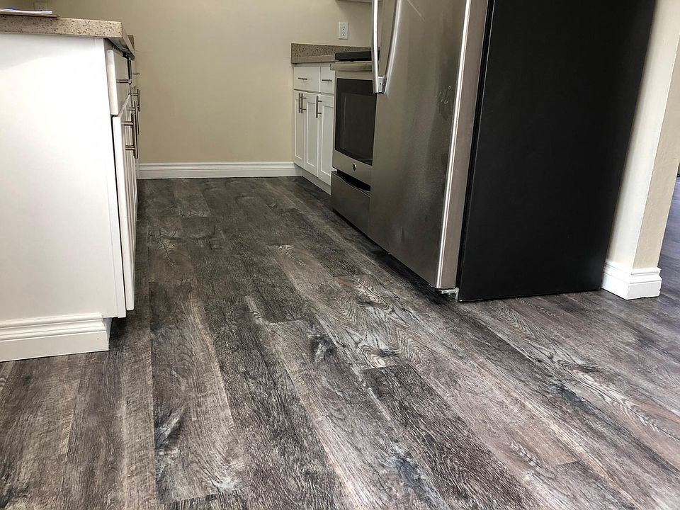 a kitchen with wood floors and a refrigerator