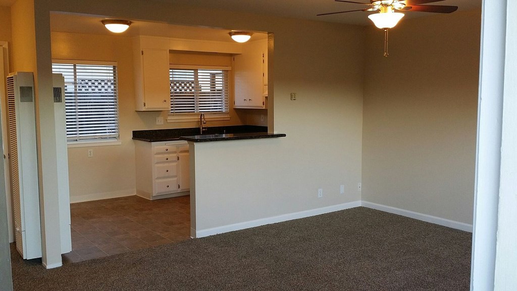 A kitchen area with a sink, countertop, and cabinets.