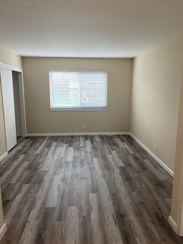 A room with a window and wooden flooring.
