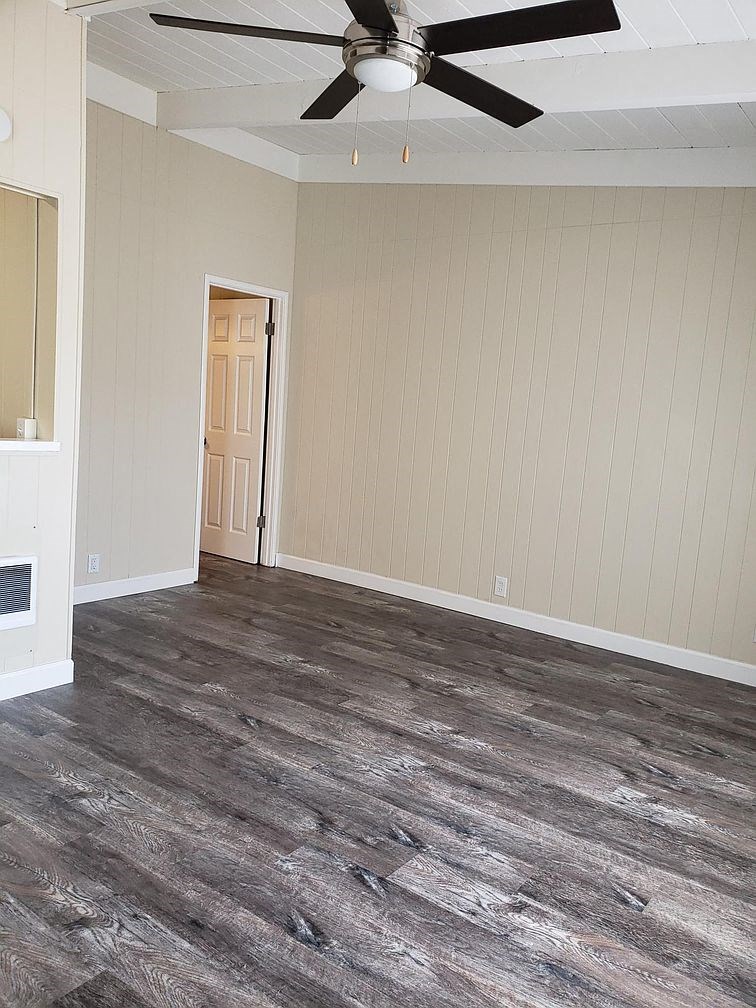 A room with a ceiling fan and a door.