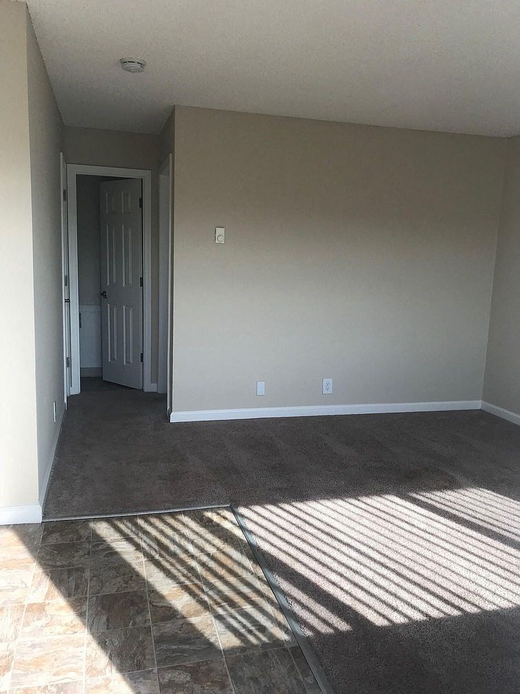an empty living room with sunlight shining on the floor