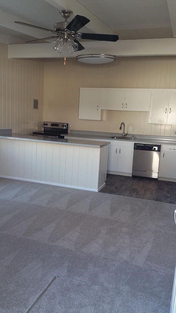 A kitchen with a ceiling fan and a counter.