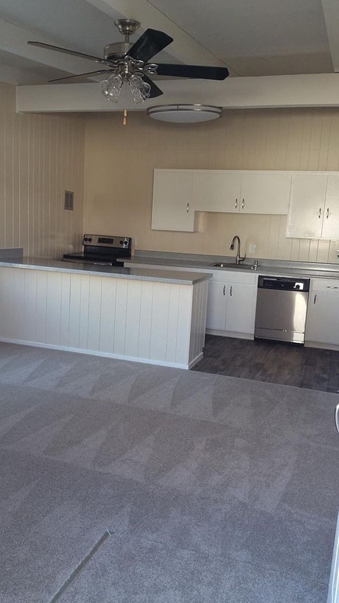 A kitchen with a ceiling fan and a counter.