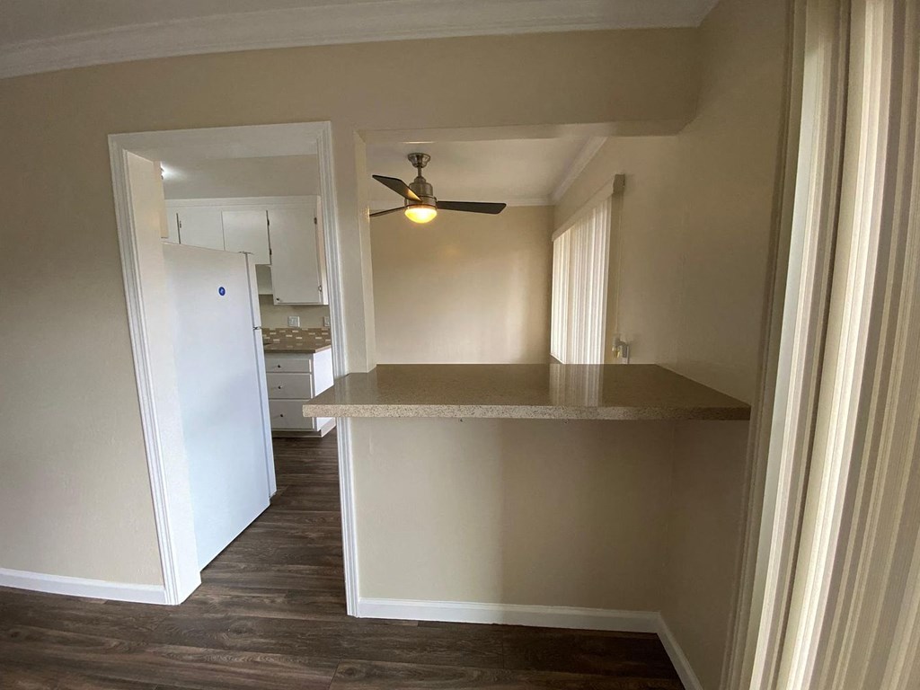 A kitchen with a white refrigerator and a ceiling fan.
