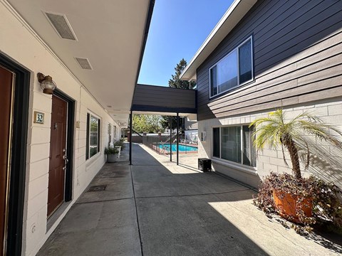 A sunny day at a residential area with a pool and a house numbered 52.