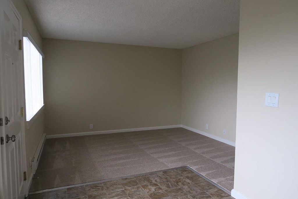 an empty living room with a wood floor