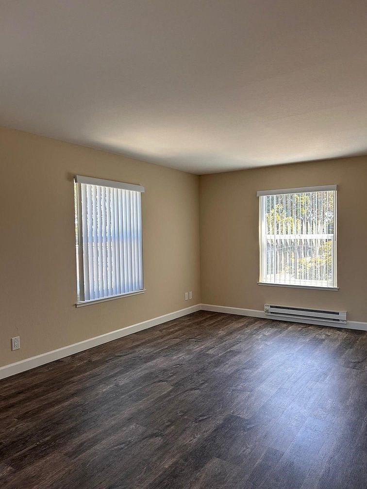 an empty living room with three windows