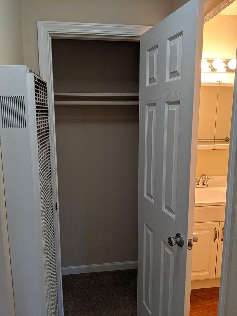 A white door is open to a room with a white sink.