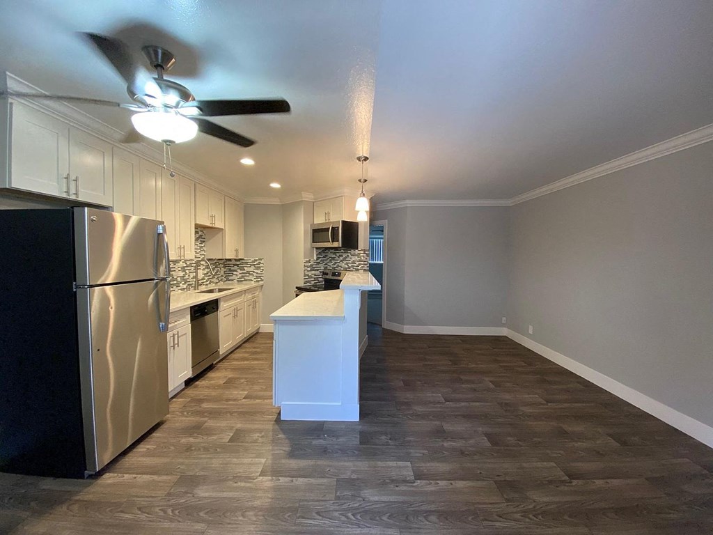 A kitchen with a refrigerator, sink, and countertop.