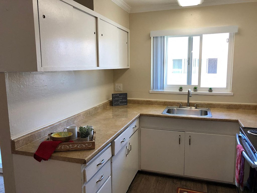 A kitchen with white cabinets and a sink.