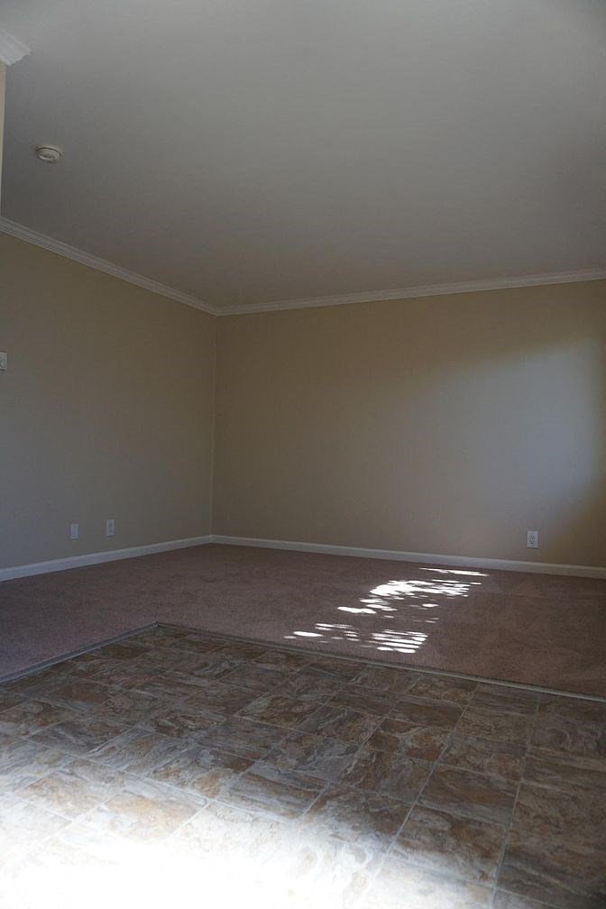 an empty room with brown walls and a tiled floor
