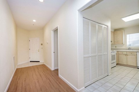 A kitchen with white cabinets and a white door.