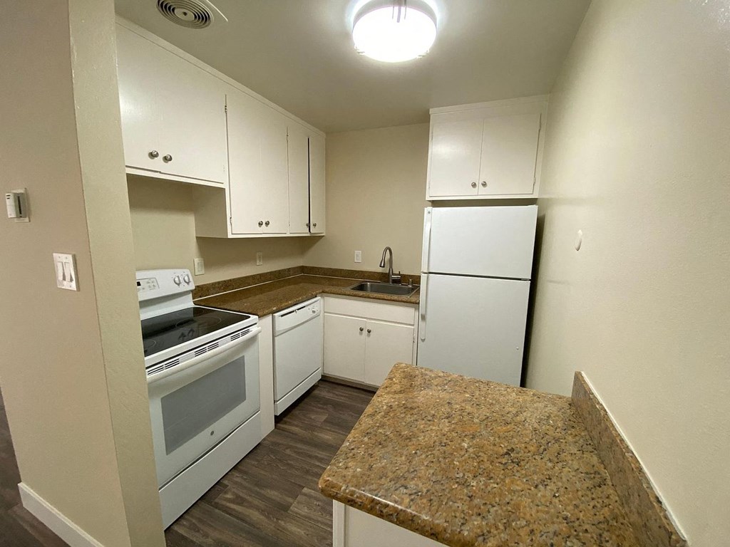 a kitchen with white appliances and granite counter tops