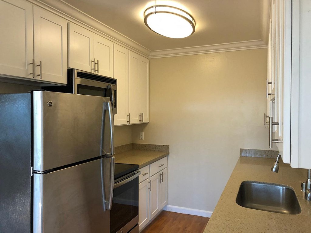 a kitchen with stainless steel appliances and white cabinets