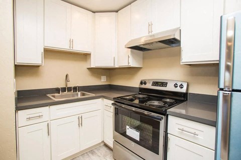 A kitchen with white cabinets and a black stove top oven.
