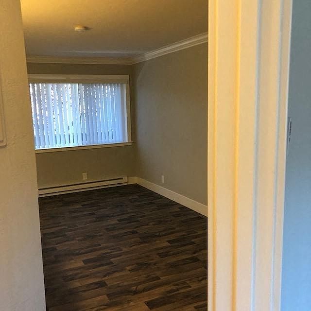 A room with a window and wooden flooring.