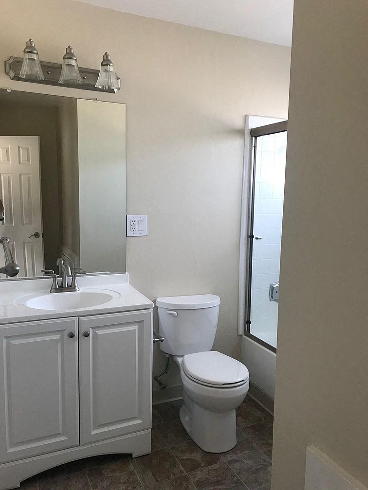a bathroom with a toilet and a sink and a shower