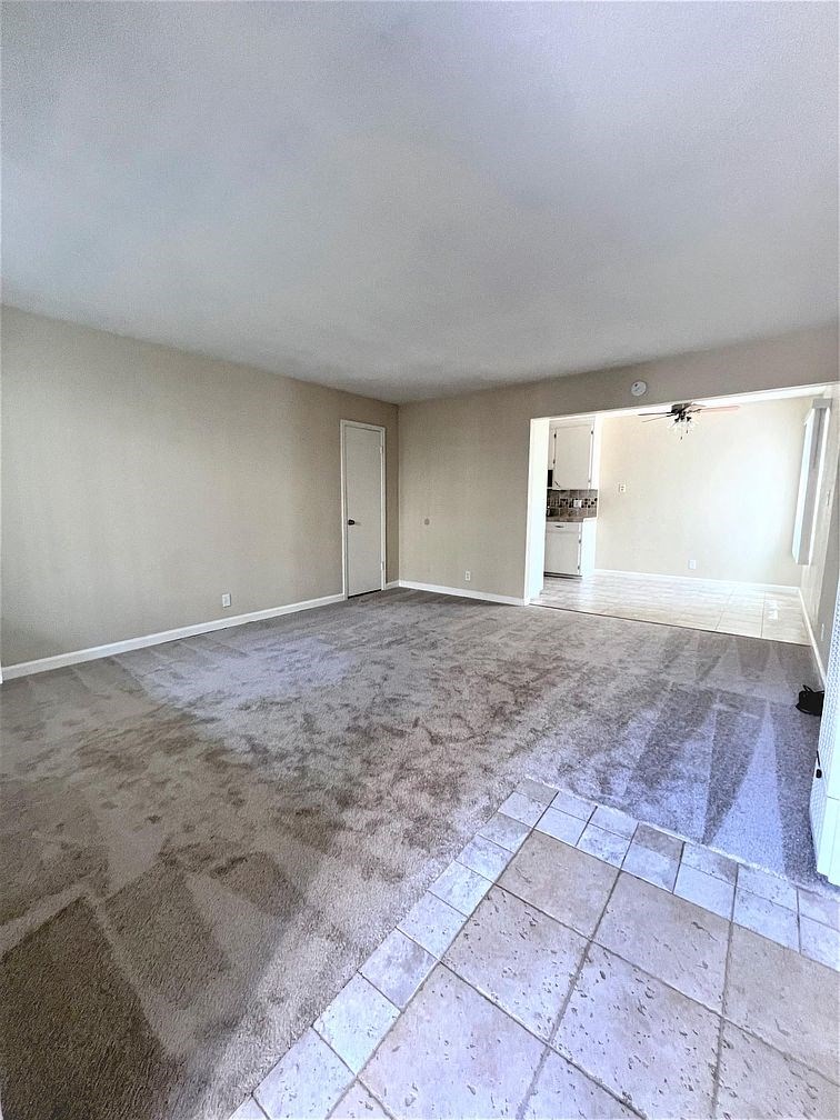 A room with a carpeted floor and a doorway leading to another room.