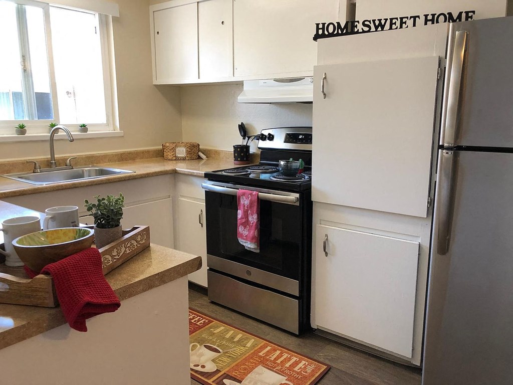 A kitchen with a white refrigerator and a black stove top oven.