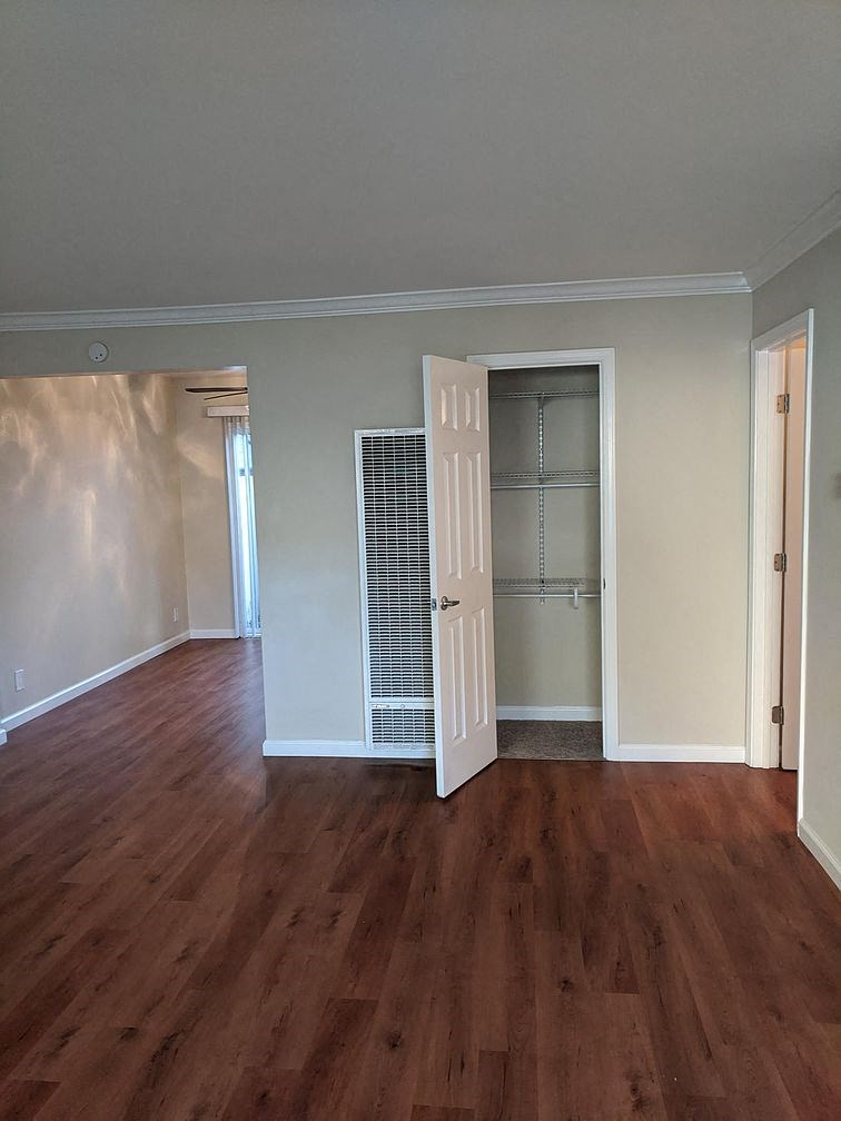 an empty living room with a door to a closet